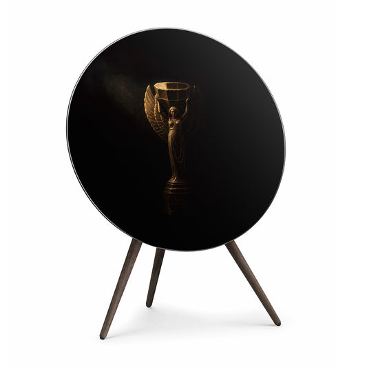 Bang & Olufsen BeoPlay A9 and BeoSound A9 speaker cover replacement Nike by Tegrino Studio featuring golden winged victory goddess sculpture on deep black background with dramatic chiaroscuro lighting, printed on acoustically transparent fabric