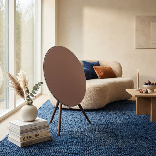 Bang & Olufsen BeoPlay A9 and BeoSound A9 speaker cover Solid Colors by Tegrino Studio in a Scandinavian-inspired living space, featuring warm terracotta solid surface on deep blue woven rug with pampas grass and art books