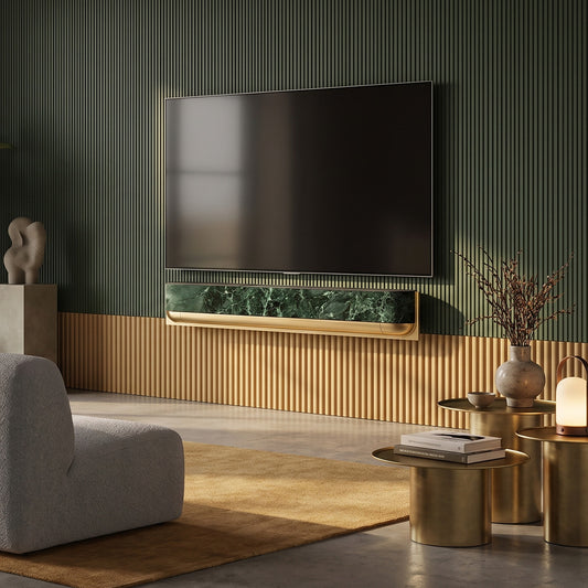 Bang & Olufsen BeoSound Theatre skin in Verde St. Denis green marble design mounted below wall TV in luxe living room with fluted gold and sage green paneling, brass side tables