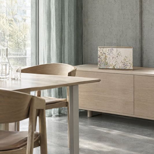 Bang & Olufsen Beosound Level with the Herbarium cover by Tegrino Studio on an oak sideboard beside a dining table