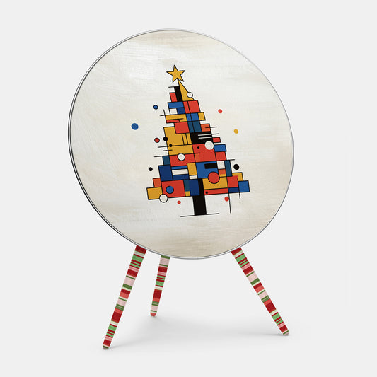 Bang & Olufsen Beoplay A9 speaker cover Mondrian Noël by Tegrino Studio, a Christmas tree built from red, yellow and blue blocks and black lines with a gold star on brushed ivory, printed on acoustically transparent fabric, shown with the matching striped legs cover
