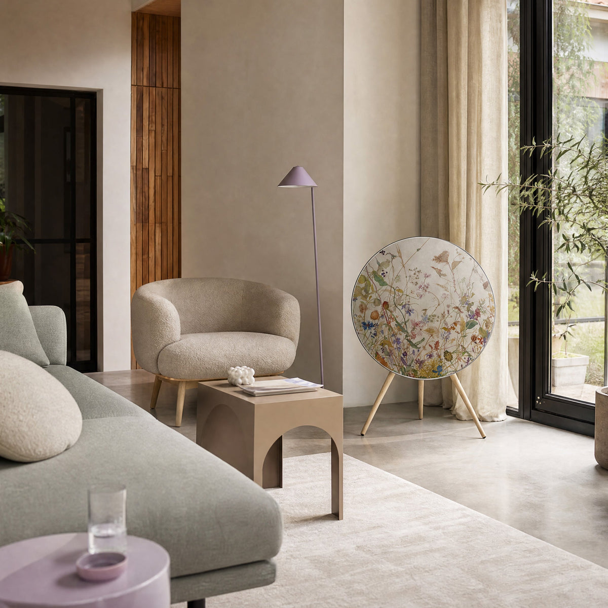 Bang & Olufsen BeoPlay A9 with the Herbarium cover by Tegrino Studio beside tall windows and a pale linen sofa