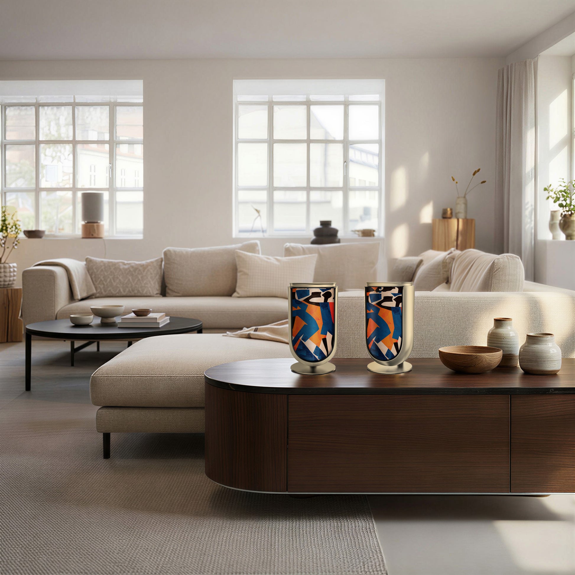 Bang & Olufsen BeoLab 8 speaker covers Verve by Tegrino Studio in a Scandinavian-inspired environment, presenting bold figurative silhouettes in vivid blue, orange and red on stereo pair atop dark walnut sideboard in bright minimal living room with cream sofa and natural light