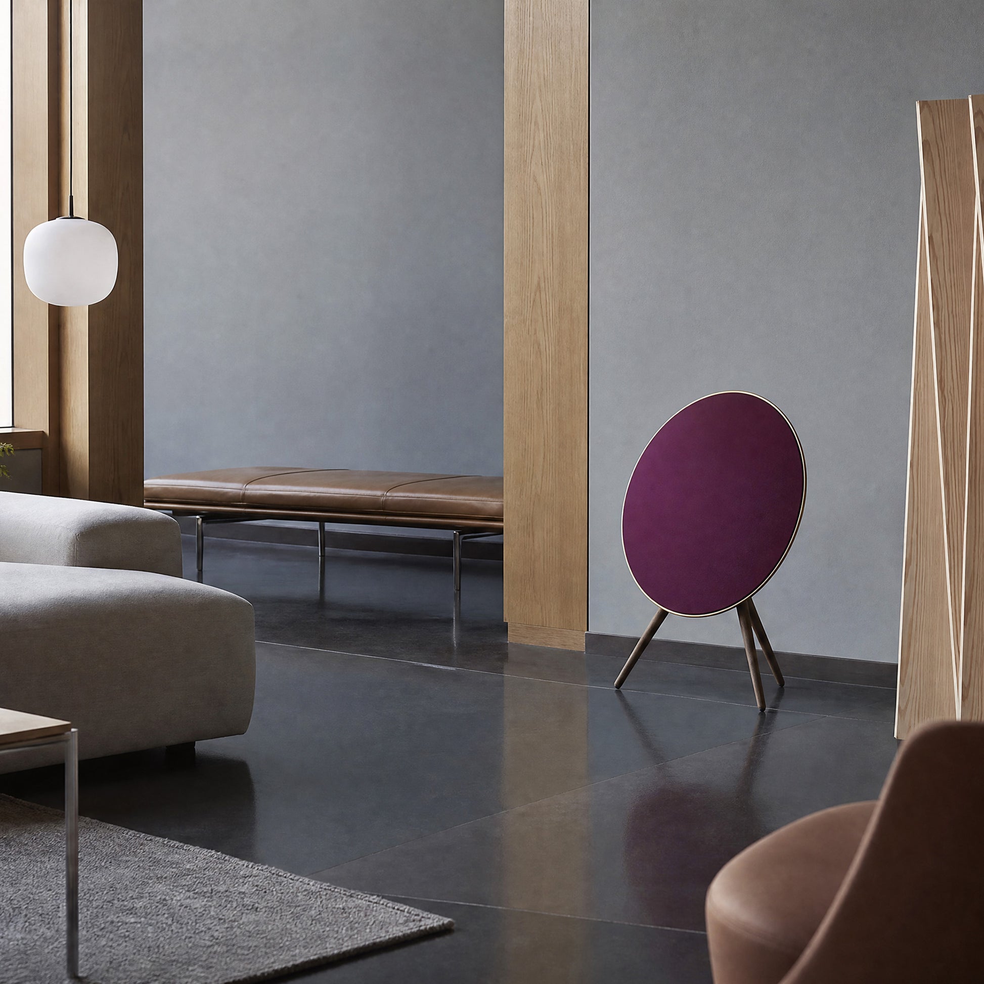 Bang & Olufsen BeoPlay A9 with the Damson cover by Tegrino Studio in a grey living room beside a tan leather bench and a light oak column