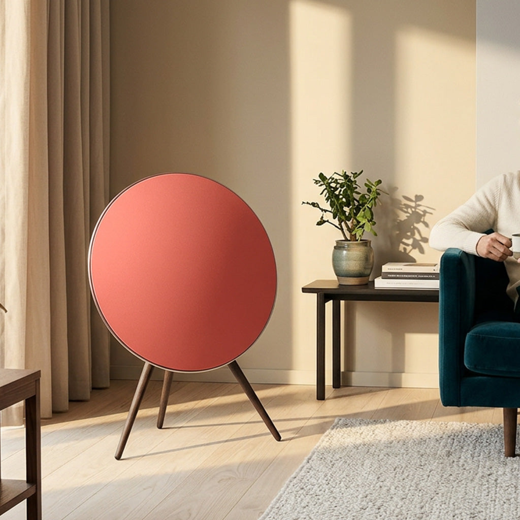 Bang & Olufsen BeoPlay A9 and BeoSound A9 speaker skin Solid Colors by Tegrino Studio in a warm residential setting, featuring coral red solid surface beside a teal velvet armchair in softly lit Scandinavian interior