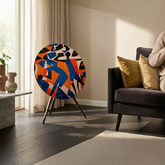 Bang & Olufsen BeoPlay A9 and BeoSound A9 speaker skin Verve by Tegrino Studio in a contemporary living space, showcasing bold figurative silhouettes in vivid blue, orange and red beside a dark sofa with mustard cushions on dark hardwood floor