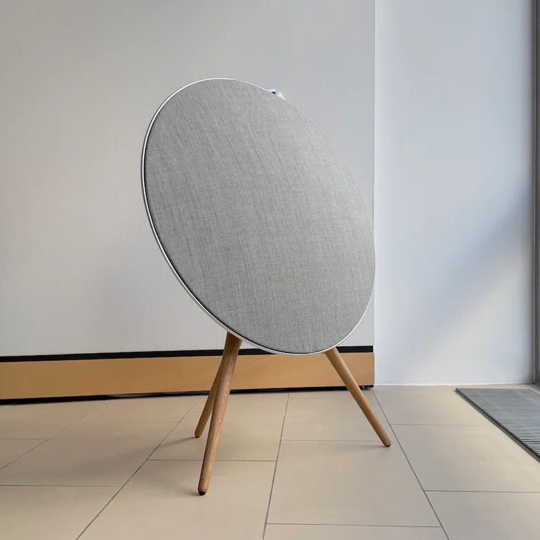 Bang & Olufsen BeoPlay A9 and BeoSound A9 Kvadrat cover Natural by Bang & Olufsen in a contemporary living space, showcasing natural grey wool blend textile and oak legs from overhead angle on beige tile floor