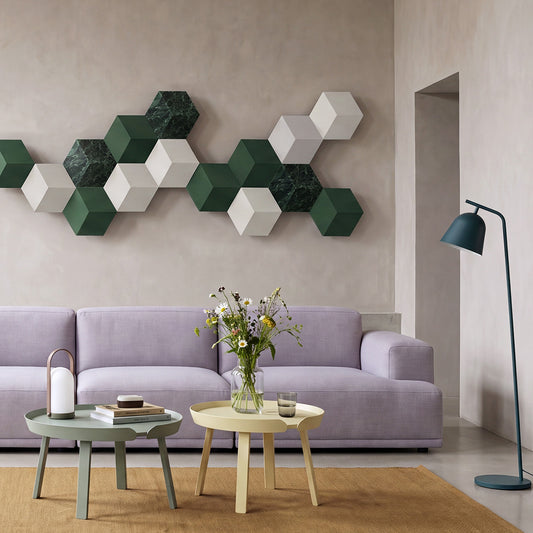 Bang & Olufsen BeoSound Shape wall with Verde St. Denis green marble skins among green and white tiles, above a lilac sofa