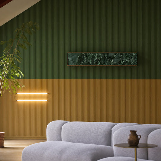 Bang & Olufsen BeoSound Stage in a Verde St. Denis green marble skin, mounted on a green wall above a bouclé sofa