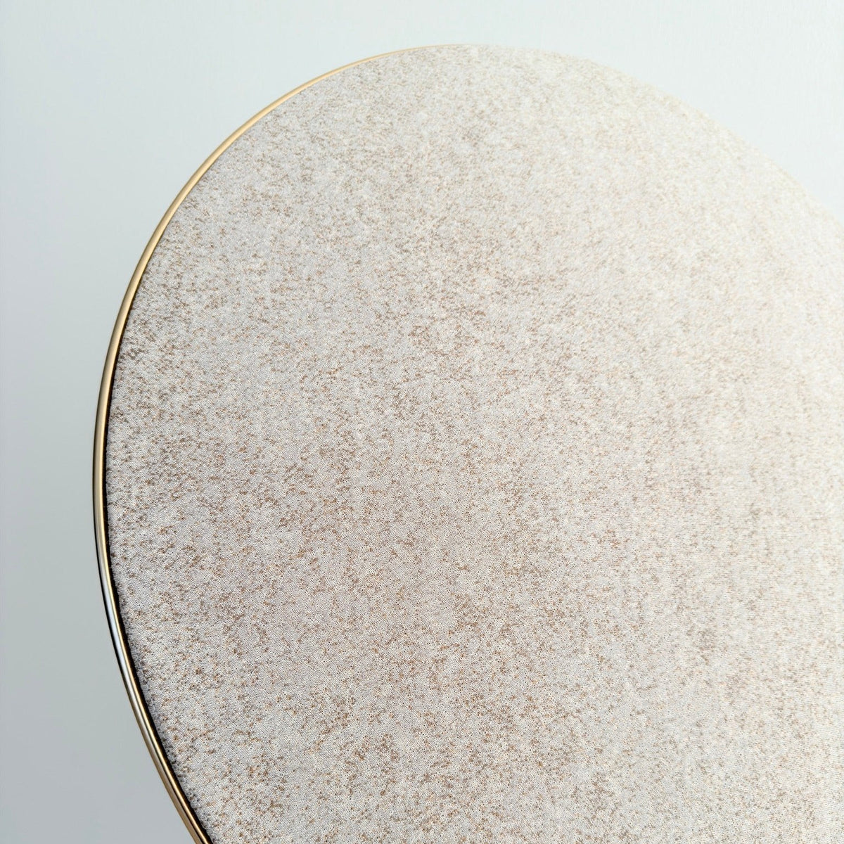 Bang & Olufsen Beoplay A9 and Beosound A9 Kvadrat Woolscape cover Golden by Bang & Olufsen, close-up of the pale gold and sand knitted wool texture beside the gold-tone rim in natural daylight