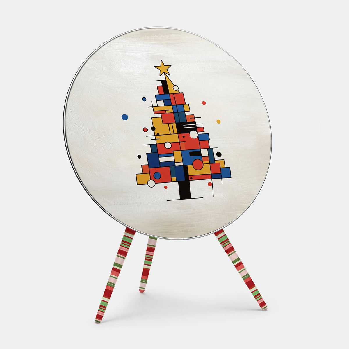 Bang & Olufsen Beoplay A9 speaker cover Mondrian Noël by Tegrino Studio, a Christmas tree built from red, yellow and blue blocks and black lines with a gold star on brushed ivory, printed on acoustically transparent fabric, shown with the matching striped legs cover