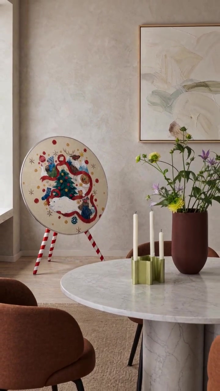 Christmas Tale cover with the candy-cane striped legs cover by Tegrino Studio on a Bang & Olufsen Beosound A9 beside a dining table with candles and flowers
