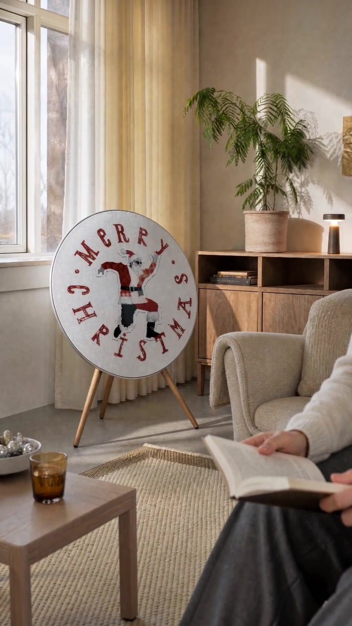 Dancing Santa cover by Tegrino Studio on a Bang & Olufsen Beosound A9 in a sunlit living room, a cat walking past to the reading armchair