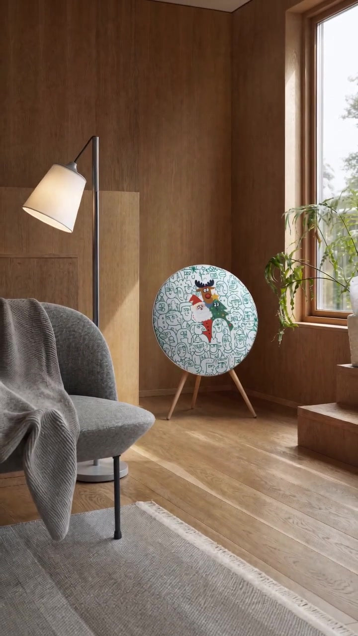 Spot the Santa cover by Tegrino Studio on a Bang & Olufsen Beosound A9 in a wood-panelled living room, a child chasing a ball of green yarn